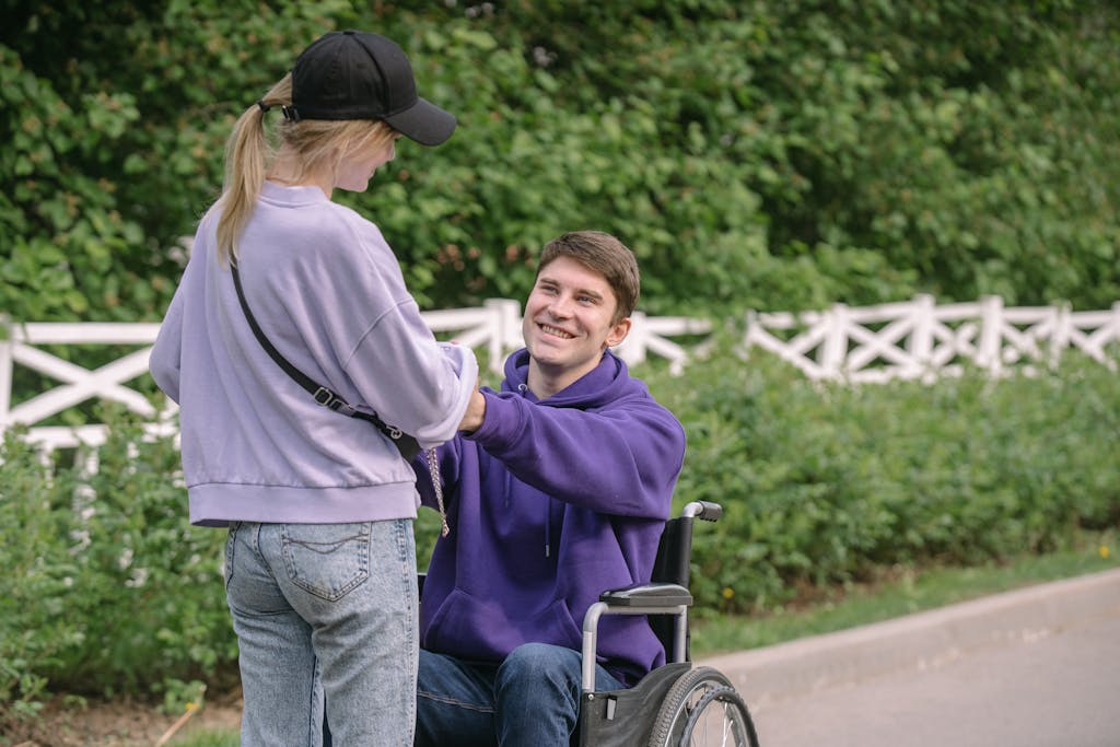 Man in a Wheelchair Holding His Girlfriend Hands